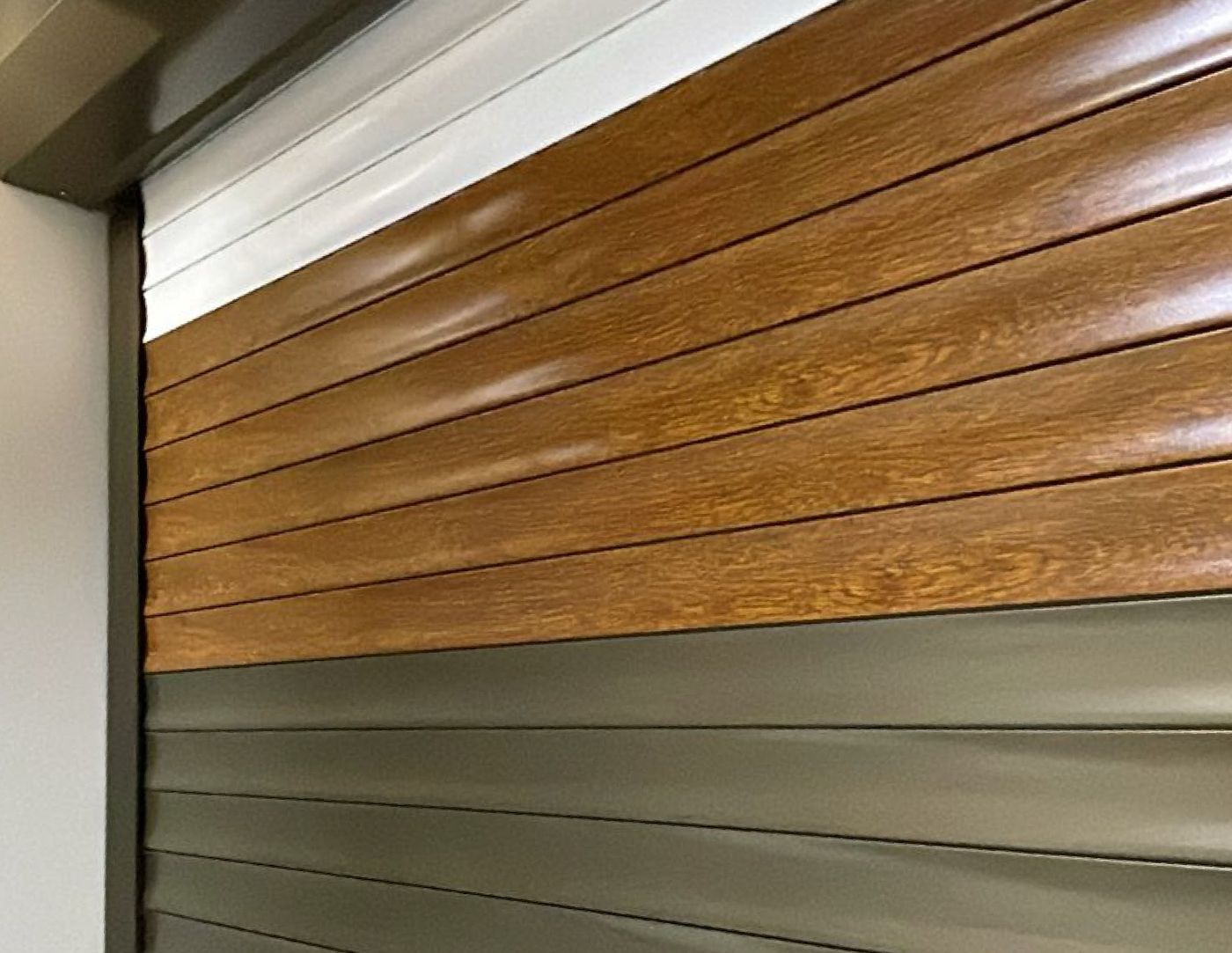 Persianas exteriores de aluminio en color madera y bronce instaladas en una ventana